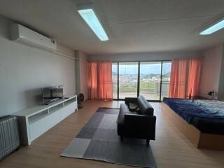 Spacious bedroom with large windows and city view