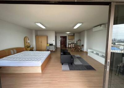 Spacious bedroom with integrated living area and city view