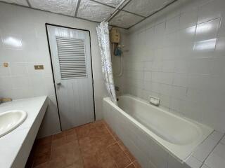 Spacious bathroom with bathtub and white tiles