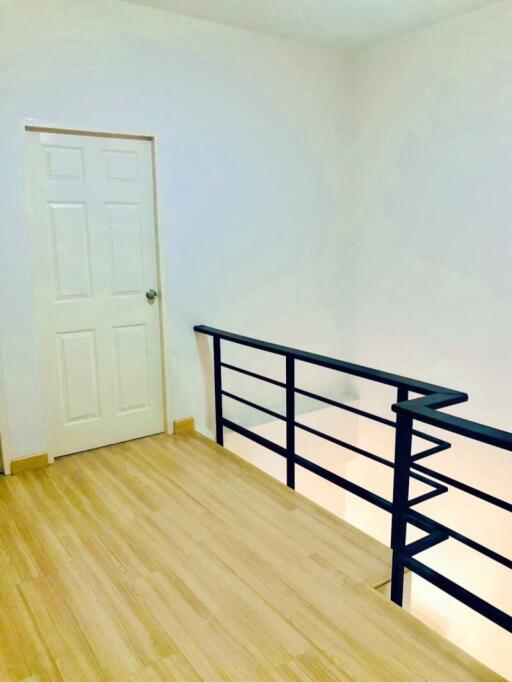 Bright hallway with wooden flooring and white walls