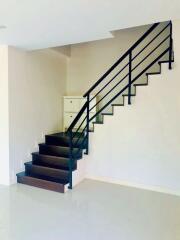 Modern staircase in a residential home with white walls and dark steps