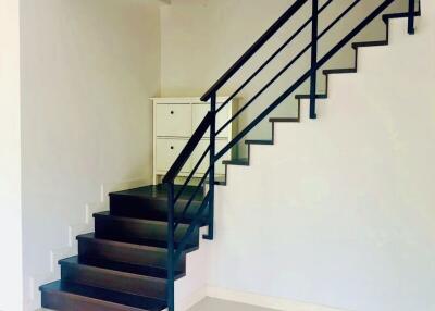 Modern staircase in a residential home with white walls and dark steps