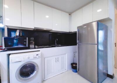 Modern kitchen with white cabinets, stainless steel appliances, and washing machine