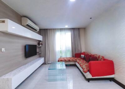 Modern living room interior with comfortable red sofa, sleek TV console and large window with curtains