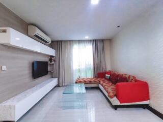 Modern living room interior with comfortable red sofa, sleek TV console and large window with curtains