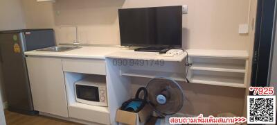 Compact kitchen area with modern appliances and flatscreen TV