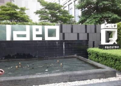 Exterior wall of a building with IDEO logo and water feature