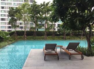 Tranquil outdoor swimming pool surrounded by greenery in a residential building complex