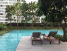 Tranquil outdoor swimming pool surrounded by greenery in a residential building complex