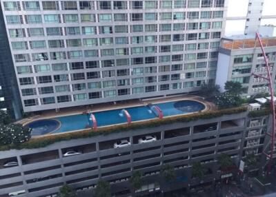 High-rise building with rooftop pool and parking garage