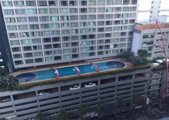 High-rise building with rooftop pool and parking garage