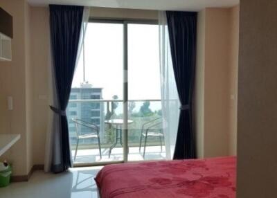 Modern bedroom with floor-to-ceiling windows and balcony access