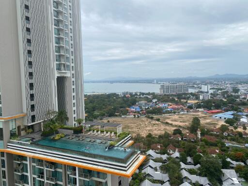 Panoramic city view from a high-rise building with a visible swimming pool