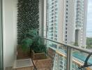 High-rise apartment balcony with ocean view, plant wall, and wicker furniture