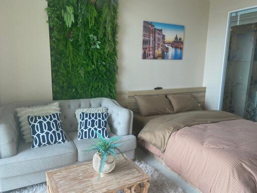 Cozy bedroom with a green living wall, comfortable bed, and a touch of art