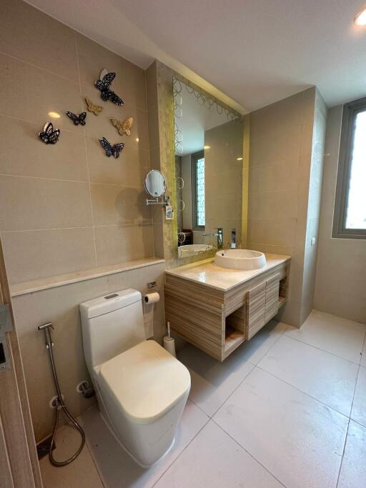 Modern bathroom with beige tiles and decorative butterflies