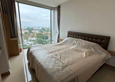 Spacious bedroom with large window offering city views