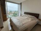 Spacious bedroom with large window offering city views