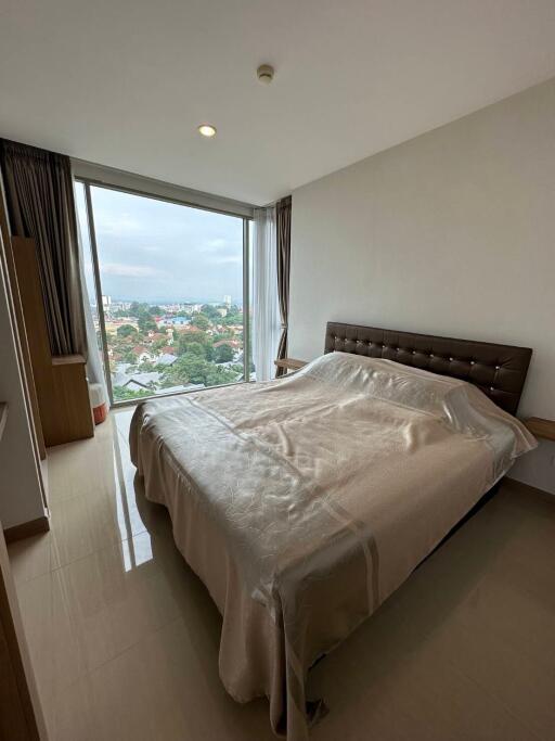 Spacious bedroom with large window offering city views