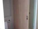 Compact bathroom with wooden cabinet and glass shower door