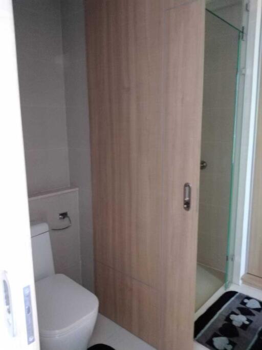 Compact bathroom with wooden cabinet and glass shower door