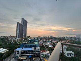 Panoramic view from a high-rise balcony at dusk showing surrounding buildings and skyline