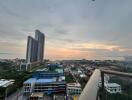 Panoramic view from a high-rise balcony at dusk showing surrounding buildings and skyline