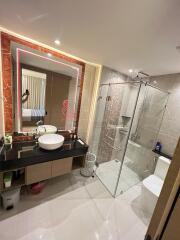 Modern bathroom with glass shower enclosure and illuminated mirror