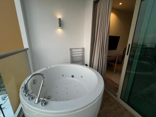 Spacious bathroom with a modern jacuzzi tub and outdoor access