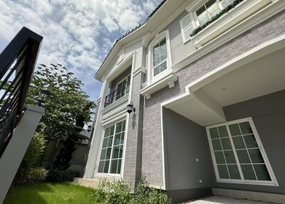 Modern two-story house with a beautiful front yard and clear skies