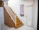 Bright entrance hall with wooden staircase and white walls