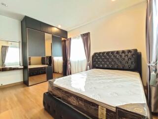 Spacious bedroom with large bed, mirrored wardrobe, and ample natural light