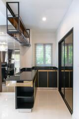 Modern kitchen with black cabinetry, stainless steel appliances, and an open shelving unit