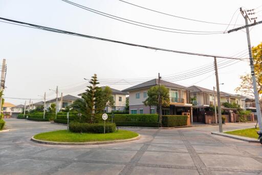 Suburban neighborhood with modern houses and a neatly paved street on a clear day