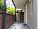 Narrow paved side yard with privacy wall and covered walkway
