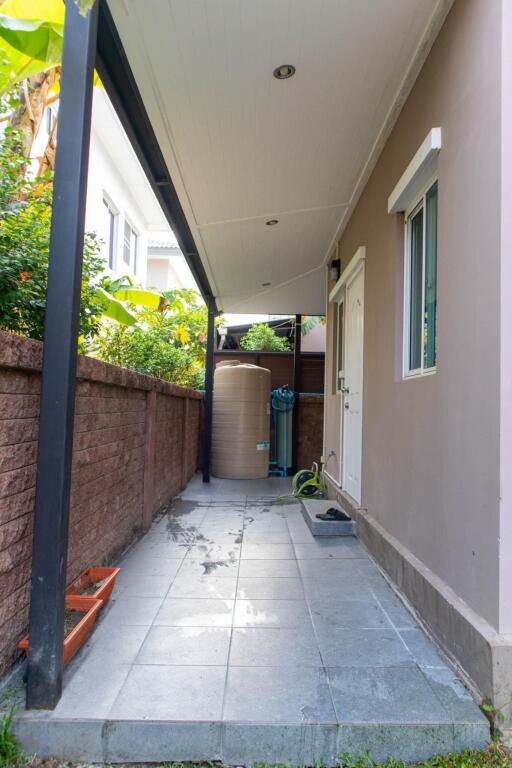 Narrow paved side yard with privacy wall and covered walkway