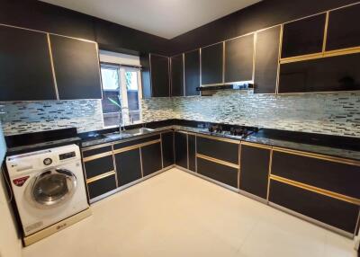 Modern kitchen with black cabinetry and built-in appliances