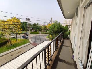 Spacious balcony with a view of a residential street and greenery