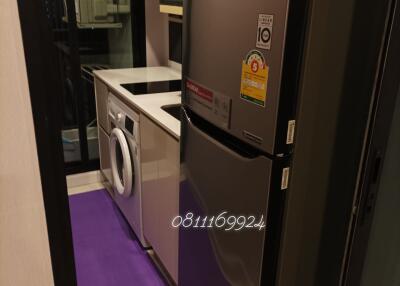 Modern appliances in a compact utility room with a washing machine and a refrigerator