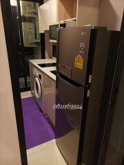 Modern appliances in a compact utility room with a washing machine and a refrigerator
