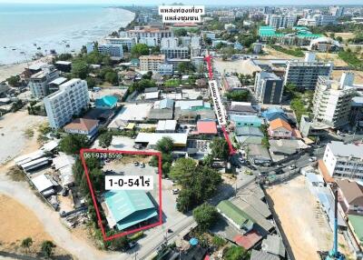 Aerial view of coastal real estate property with surrounding buildings and proximity to the beach
