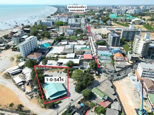 Aerial view of coastal real estate property with surrounding buildings and proximity to the beach