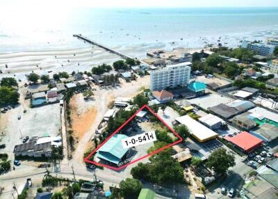 Aerial view of a coastal property with marked boundaries near a beach