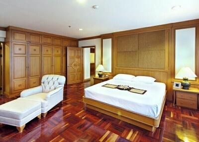 Elegant and spacious bedroom with hardwood floors and ample natural light