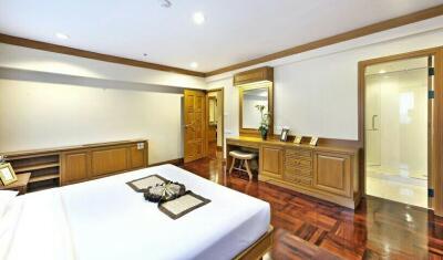 Spacious bedroom with wooden flooring and built-in cabinets