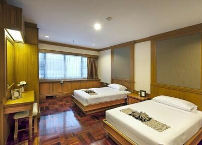 Spacious bedroom with two beds and wooden furnishings