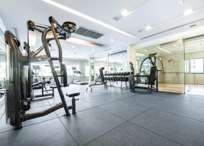 Spacious gym with modern equipment and mirrored walls