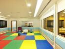 Bright and spacious children's playroom with colorful floor mats and toys
