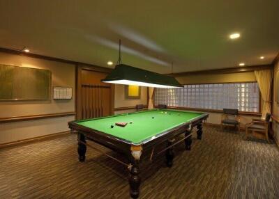 Elegant billiard room with a large pool table, ambient lighting and comfortable seating area