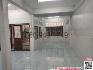 Spacious empty interior of a building with tiled floors and multiple doors